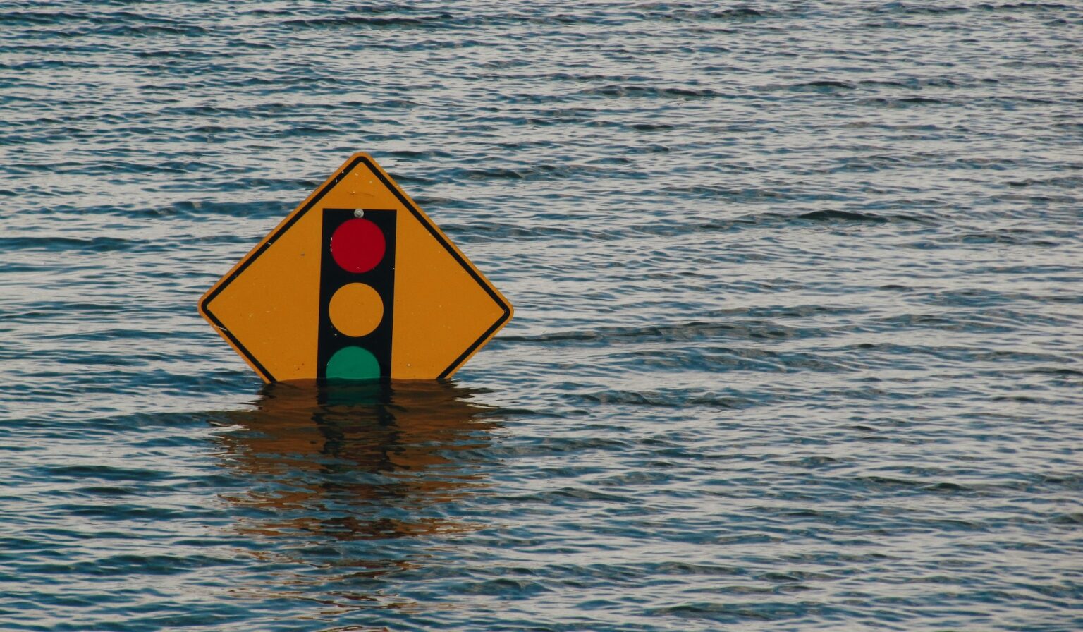 Streetlight sign partially submerged under water